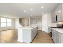 Open-concept kitchen with stainless steel appliances, gray cabinets, and a center island with a sink at 6957 Hornbeam Cir, Brownsburg, IN 46112