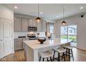 Modern kitchen with gray cabinets, white quartz island, and stainless steel appliances at 6957 Hornbeam Cir, Brownsburg, IN 46112