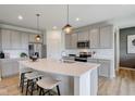 Modern kitchen with gray cabinets, white quartz island, and stainless steel appliances at 6957 Hornbeam Cir, Brownsburg, IN 46112