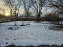 Large backyard with a partially snow-covered lawn, partially fenced at 821 Shellbark Rd, Anderson, IN 46011