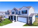 Two story homes with gray and white siding, and a pond in the background at 9965 Redwood Peak Ln, Indianapolis, IN 46259