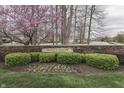 Stone wall and shrubbery at Wolf Run community entrance, accented by a beautiful flowering tree at 10402 Shakamak Way, Indianapolis, IN 46239