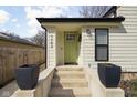 Charming home with bright green door, black trim windows, and concrete porch at 1102 N Newman St, Indianapolis, IN 46201