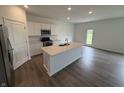 Modern kitchen with white cabinets, stainless steel appliances, and a large island with a sink at 116 Marble Wood Dr, Danville, IN 46122