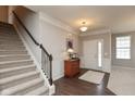 Foyer featuring a staircase, hardwood floors, a stylish table, and neutral decor at 15349 Eastpark W Cir, Fishers, IN 46037