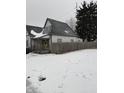 Snow covered lawn and charming craftsman style home with yellow door at 243 E Caven St, Indianapolis, IN 46225