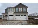 Two-story home featuring a two-car garage, tan and brown siding and a white brick facade at 4384 Risen Star Way, Bargersville, IN 46106