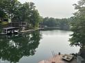 Scenic lake view with private dock and boat slip provides tranquil waterfront living amid lush green trees at 7018 Drum Dr, Nineveh, IN 46164