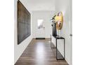 Bright foyer with wood-look floors, a console table, and large wall art at 733 Penrose Pl, Danville, IN 46122