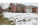 Brick front of house with attached garage, partially covered in snow at 8042 Hazen Way, Indianapolis, IN 46216