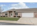 Charming brick home featuring a well-maintained lawn and attached two-car garage at 116 Jasper Way, Anderson, IN 46012