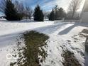 Snowy backyard with a small patch of grass and a white picket fence at 11663 Congressional Ln, Indianapolis, IN 46235