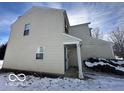 Tan vinyl siding and a covered side entrance with snow on the ground at 11663 Congressional Ln, Indianapolis, IN 46235