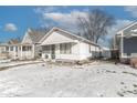 White bungalow home with a snow-covered yard at 1311 N Grant Ave, Indianapolis, IN 46201