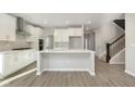 Open kitchen with white cabinets, island, and stainless steel appliances at 14403 Bishop Birch Pl, Carmel, IN 46032