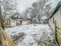 Fenced backyard with basketball hoop and snowy ground at 216 W 27Th St, Anderson, IN 46016