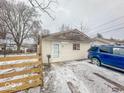 Small ranch home with damaged roofline and snowy yard at 216 W 27Th St, Anderson, IN 46016