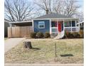 This blue single story home is a gem with a red door, white trim and carport at 50 N Edmondson Ave, Indianapolis, IN 46219