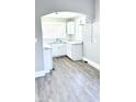 Bright kitchen with white cabinets, marble countertops, and grey vinyl plank flooring at 52 N Mount St, Indianapolis, IN 46222