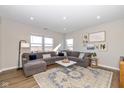 L-shaped living room with a gray sectional sofa and large windows at 8576 Jeff Cir, Brownsburg, IN 46112