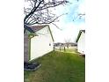 Side view of green grass and a partial view of home with fenced yard and green gutters at 1520 Wilford Ln, Indianapolis, IN 46229