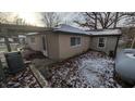 Tan house with snow covered yard, side view with shed at 3 Lake Hart, Mooresville, IN 46158