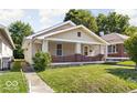 A cozy single-story house with a well-manicured lawn and inviting front porch at 3614 E New York St, Indianapolis, IN 46201
