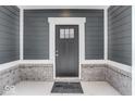 Gray front door with a brick base and white trim at 5767 Cr W 750 N, McCordsville, IN 46055