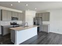 Modern kitchen with stainless steel appliances, island, and gray cabinets at 6033 Granby Dr, Whitestown, IN 46075