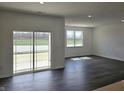 Bright living room featuring modern flooring and a sliding glass door with view to backyard at 6033 Granby Dr, Whitestown, IN 46075