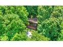 High-angle aerial view of a cedar-shingled home, complete with a vivid red porch and surrounding green canopy at 6377 N Tutterow Rd, Monrovia, IN 46157