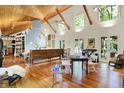 Bright, open living room with vaulted ceiling, wooden floors, a grand piano, and many windows for natural light at 6377 N Tutterow Rd, Monrovia, IN 46157