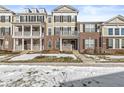Attractive three-story townhome with snow-covered lawn at 7161 Caversham Pl, Indianapolis, IN 46278