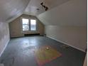 Unfinished attic bedroom with sloped ceilings and hardwood floors at 837 S Warman S Ave, Indianapolis, IN 46221