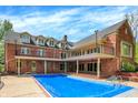 Brick home backyard with a covered swimming pool and second story balcony at 8602 Frontgate Ln, Indianapolis, IN 46256