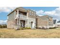Brick home with a balcony, stone accents, and a manicured lawn at 14292 Dufton Ct, Carmel, IN 46074