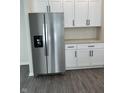 Stainless steel refrigerator complements white cabinets and gray countertops in this stylish kitchen at 1440 Wigwam Ln, Martinsville, IN 46151