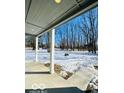 Covered porch overlooking a snow-covered backyard at 1644 Hunting Horn Cir, Indianapolis, IN 46260