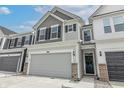 Two-story townhome with gray and white siding, gray garage door, and a brick base at 18655 Moray St, Westfield, IN 46069