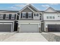 Two-story townhome with gray and white siding, gray garage door, and a brick base at 18655 Moray St, Westfield, IN 46069