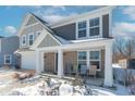 Two-story house with gray and beige siding, a white garage door, and a covered porch at 2406 Ninebark Dr, Plainfield, IN 46168