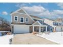 Two-story house with gray and beige siding, a white garage door, and a covered porch at 2406 Ninebark Dr, Plainfield, IN 46168