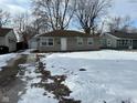 Cute ranch home with a snow-covered yard and attached garage at 2442 Asbury St, Indianapolis, IN 46203