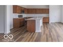 Spacious kitchen with an island, wood cabinets, and hardwood floors at 385 N Post Oak Dr, Mooresville, IN 46158