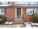 Front entrance with brick steps and storm door at 3909 S Lasalle St, Indianapolis, IN 46237