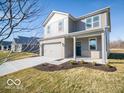 Charming two-story home featuring a two-car garage, gray brick, gray siding, a covered porch and a well-manicured lawn at 5592 Cattail Branch Ln, Clayton, IN 46118
