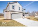 Charming two-story home featuring a two-car garage, gray brick, gray siding, and a well-manicured lawn at 5592 Cattail Branch Ln, Clayton, IN 46118