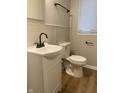 Updated bathroom with white vanity, toilet, and wood-look flooring at 9710 E 38Th St, Indianapolis, IN 46235