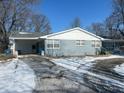 Gray brick ranch house with carport and a partially snow-covered yard at 9710 E 38Th St, Indianapolis, IN 46235