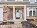 Welcoming front entrance featuring a charming porch, brick accents, and decorative wreath at 11237 Baycreek Dr, Indianapolis, IN 46236